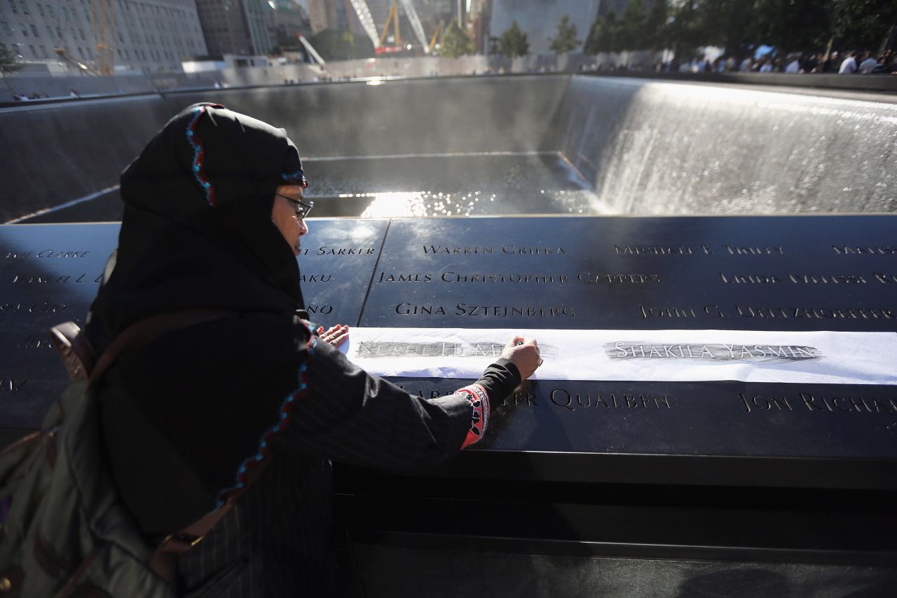 Khudeza Begum etches the name of her slain nephew from the memorial of the 9/11 attacks.