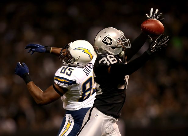Shawntae Spencer of the Oakland Raiders tries, but fails, to intercept a pass intended for Antonio Gates of the San Diego Chargers.