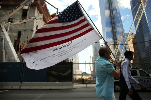 Germano Riviera carries the Flag of Honor, which displays the names of the victims of the September 11 attacks, across ground zero on Monday.