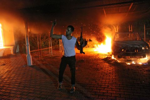 A man waves his rifle as buildings and cars are engulfed in flames inside the U.S. Consulate compound in Benghazi, Libya, late on Tuesday, September 11.