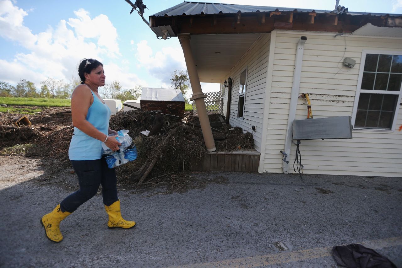 On Friday, September 7, Gina Hunter walks past the front porch of her home, which washed onto a levee in Plaquemines Parish in Braithwaite, Louisiana.  "I never expected to have the levee as my backyard," Hunter says. Louisiana officials estimate at least 13,000 homes were damaged by Hurricane Isaac. 