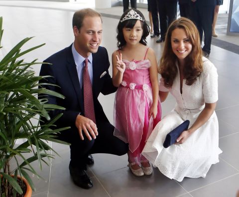 Prince William and Catherine pose with 4-year-old Maeve Low as they tour the Rolls-Royce Seletar Campus during the Diamond Jubilee tour at Seletar Aerospace Park on Wednesday, September 12, the second day of their Diamond Jubilee tour in Singapore.