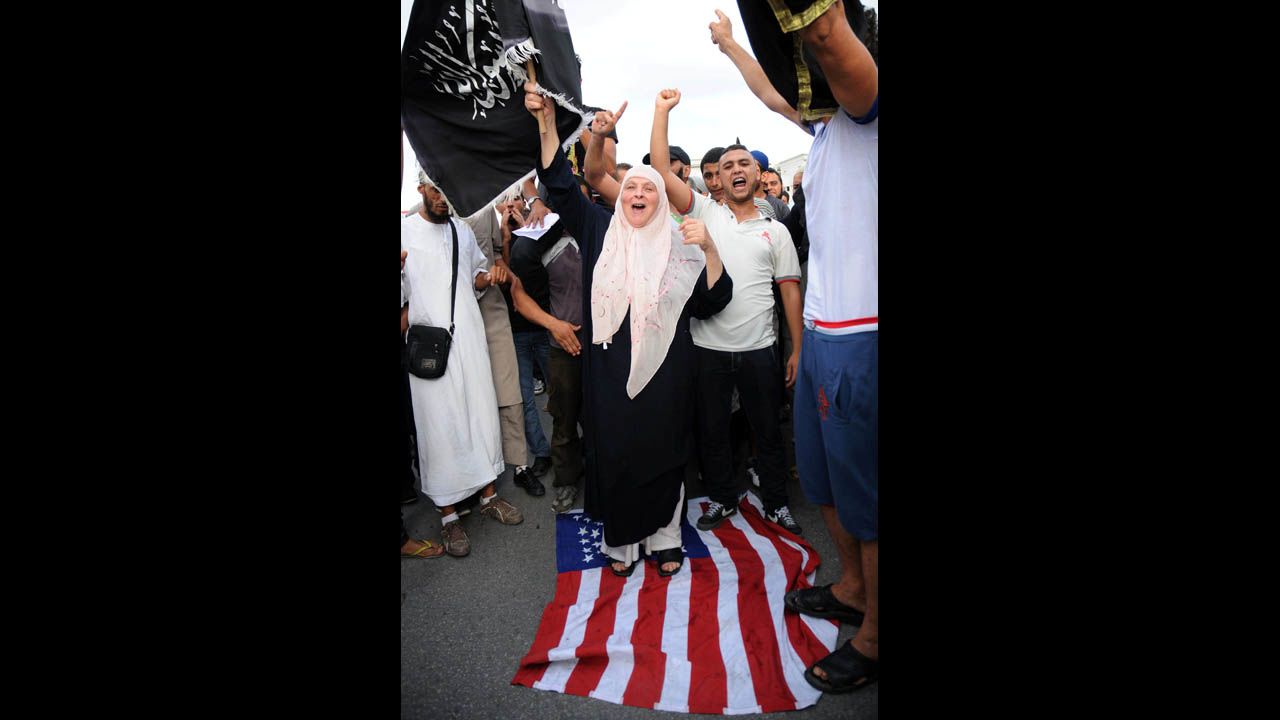 A demonstrator walks on a U.S. flag during a Wednesday's demonstration at the U.S. Embassy in Tunis.