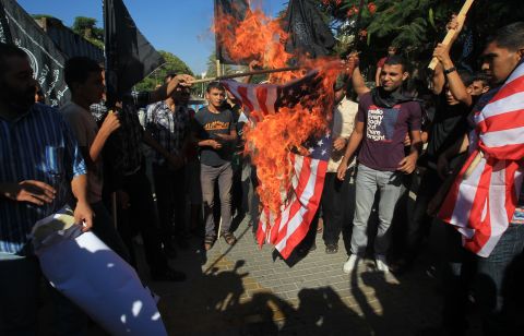 Palestinian men burn the American flag during Wednesday's demonstration in Gaza City.