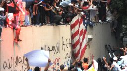 Egyptian protesters tear down the US flag at the US embassy in Cairo on September 11, 2012, during a demonstration against a film deemed offensive to Islam. 