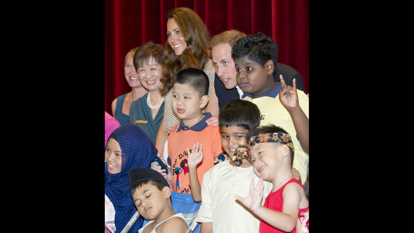 The duke and duchess pose for a picture with children as they visit The Rainbow Centre in Singapore. 
