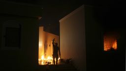 A protester reacts as the US Consulate in Benghazi is seen in flames. Armed gunmen attacked the compound, clashing with Libyan security forces before the latter withdrew as they came under heavy fire.