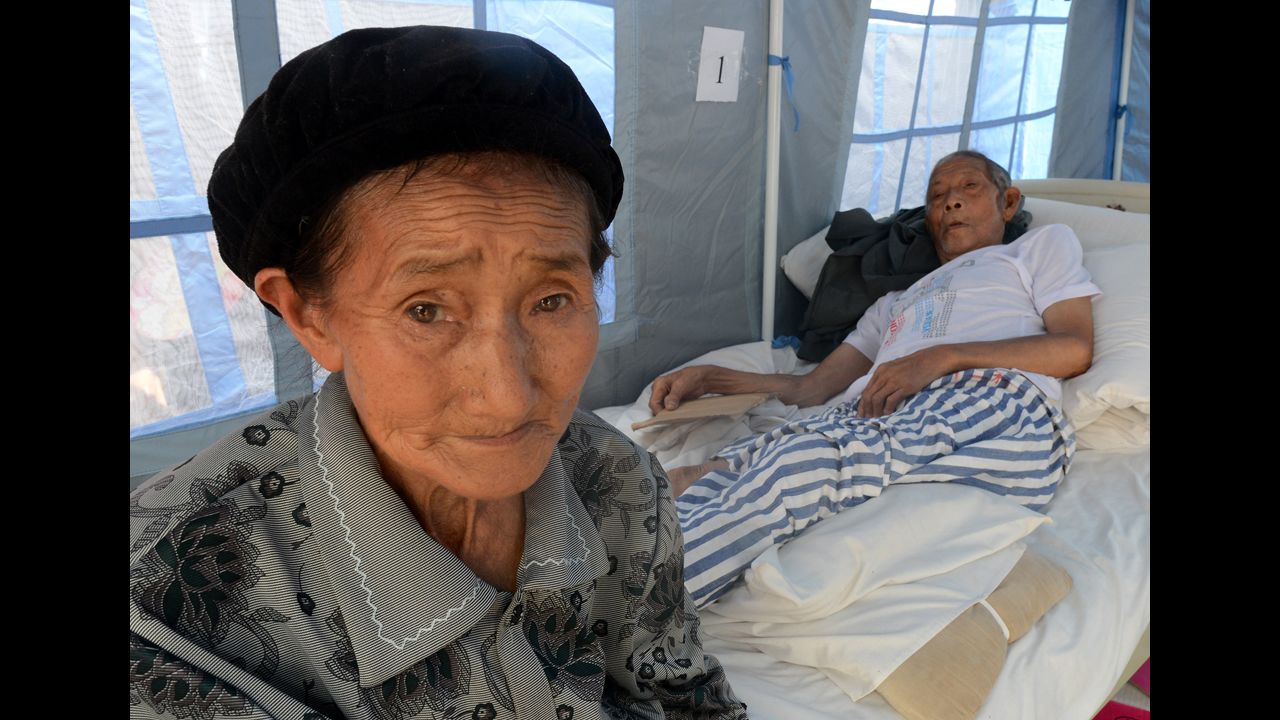 Sheng Xianqui, right, is tended by his wife at the Yiliang People's Hospital on Monday.