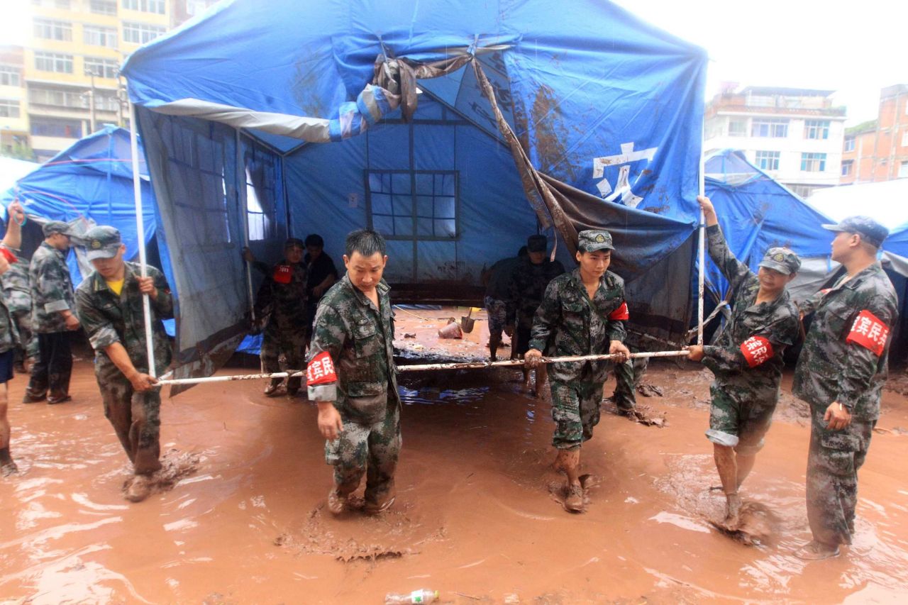 Rescuers move a tent at a temporary hospital destroyed by floodwaters on Tuesday, September 11, in Yiliang County, Yunnan Province, China. Downpours have flooded some settlements for the homeless quake victims and triggered mudslides in the mountainous county.  At least 81 people were killed and 821 others injured after two earthquakes jolted the border of Yunnan and Guizhou provinces on Friday.