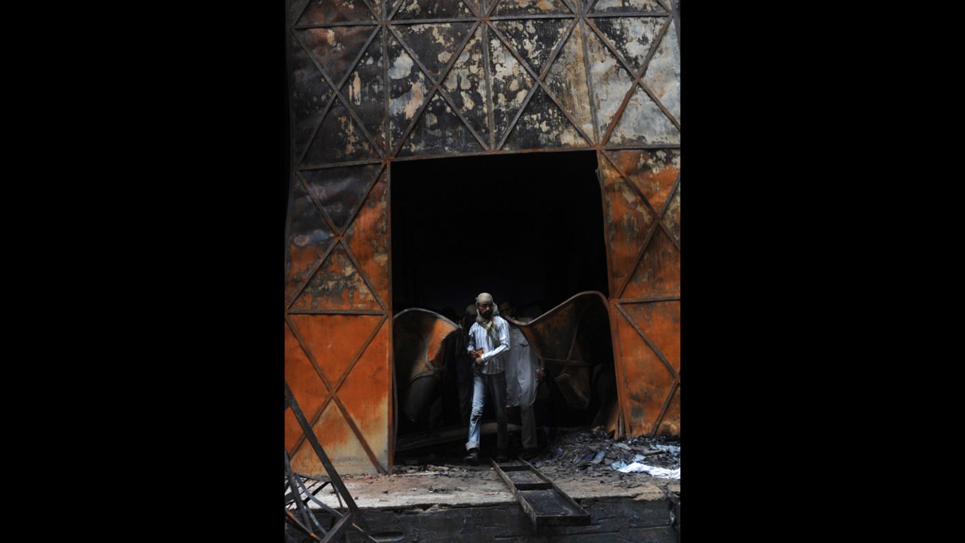 A Pakistani rescue worker leaves the burned out garment factory in Karachi Wednesday, the day after a fire there left at least 258 people dead.