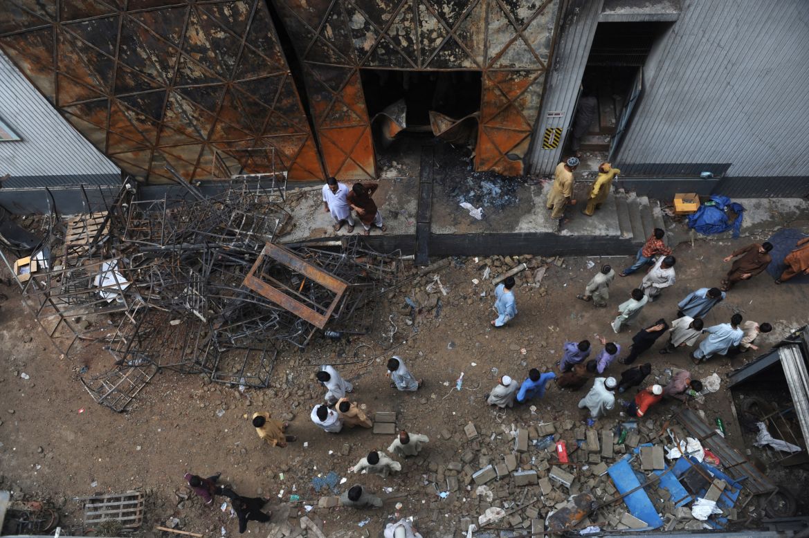 Pakistanis gather in Karachi in front of a garment factory following a fire Tuesday in which at least 258 people died.