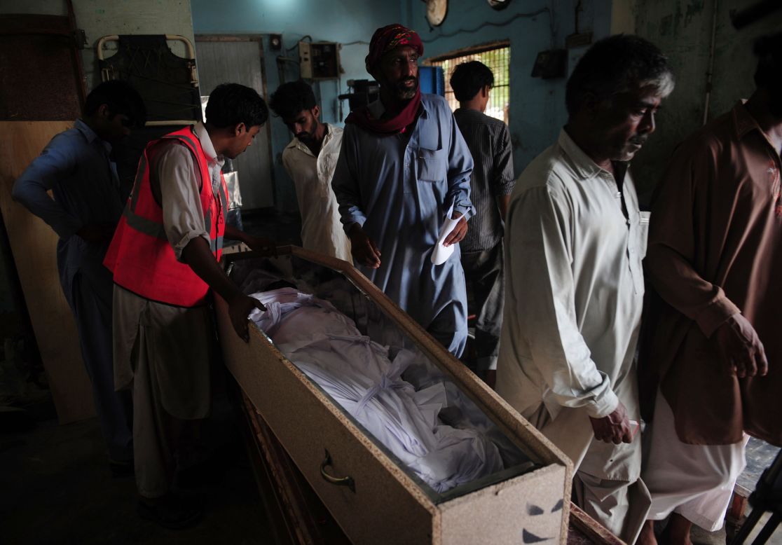 Pakistani men identify dead relatives at the EDHI Morgue in Karachi, a day after a garment factory fire killed more than 250 people. 