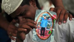 Aziz Ahmed, the father of factory worker Asif Aziz who was killed in a blaze in Karachi Wednesday, September 12, 2012, holds his son's photo as he mourns his death.