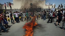 Yemeni protesters gather around fire during a demonstration outside the US embassy in Sanaa  over a film mocking Islam on September 13, 2012. Yemeni forces managed to drive out angry protesters who stormed the embassy in the Yemeni capital with police  firing warning shots to disperse thousands of people as they approached the main gate of the mission.   AFP PHOTO/MOHAMMED HUWA        (Photo credit should read MOHAMMED HUWAIS/AFP/GettyImages)
