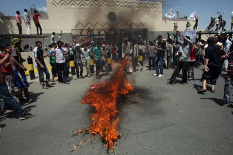 Yemeni protesters gather around a fire Thursday during a demonstration outside the U.S. Embassy in the capital of Sanaa.  Yemeni forces fired warning shots to disperse the thousands of protesters approaching the main gate of the mission.