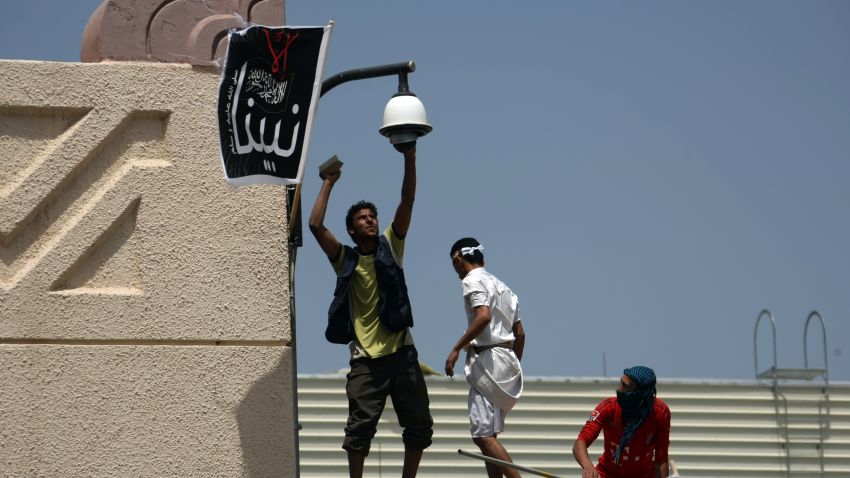 Yemeni protesters try to break the security camera of the US embassy in Sanaa during a protest over a film mocking Islam on September 13, 2012. Yemeni forces managed to drive out angry protesters who stormed the embassy in the Yemeni capital with police  firing warning shots to disperse thousands of people as they approached the main gate of the mission.   AFP PHOTO/MOHAMMED HUWAIS        (Photo credit should read MOHAMMED HUWAIS/AFP/GettyImages)