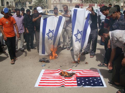 Iraqi protesters burn Israeli and U.S. flags during a protest Thursday.  The U.S. ambassador to Libya, J. Christopher Stevens, and three others were killed during a protest outside the U.S. Consulate in Benghazi, Libya, on Tuesday.