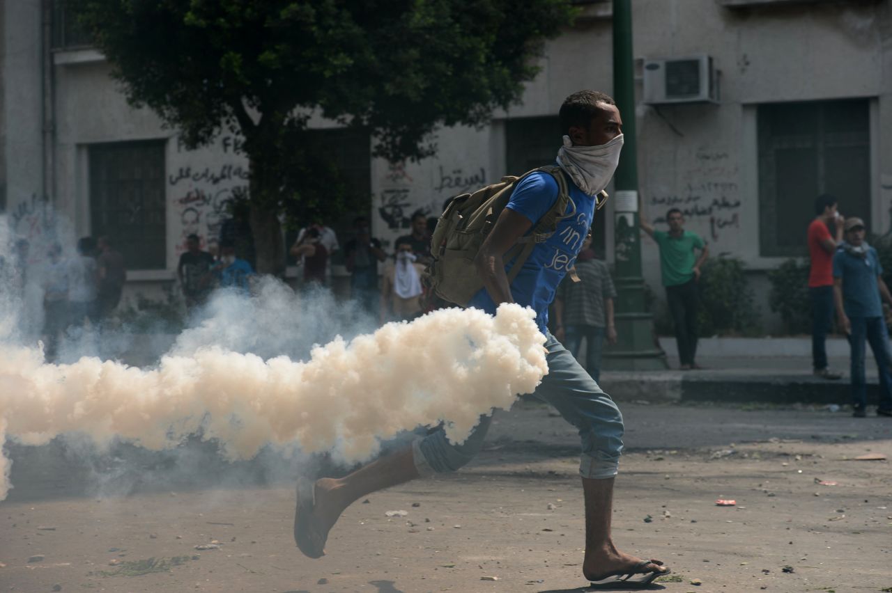 An Egyptian protester throws a tear gas canister at riot police Thursday during clashes near the U.S. Embassy in Cairo.