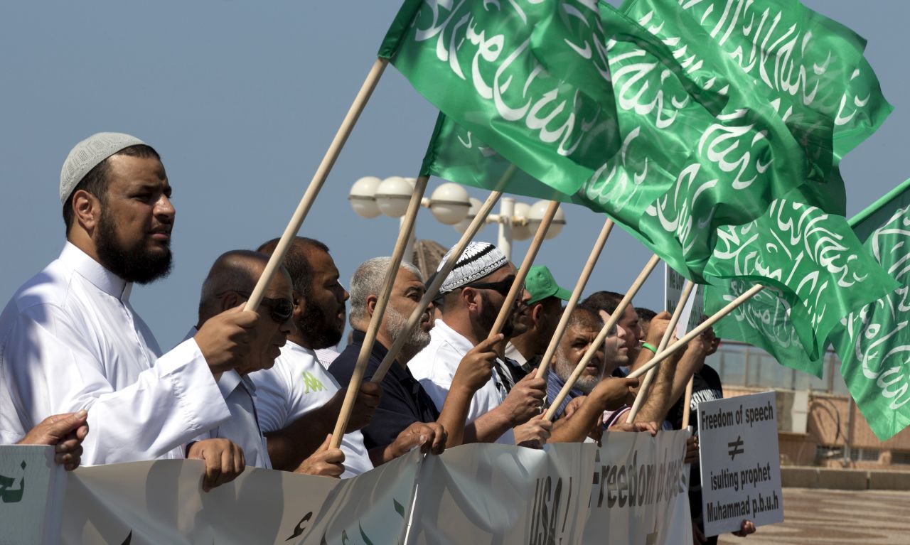 Arab-Israeli men wave green Islamic flags with the Muslim profession of belief: "There is no God but God and Mohammed is the prophet of God" during a protest in front of the U.S. Embassy on Thursday in Tel Aviv, Israel.