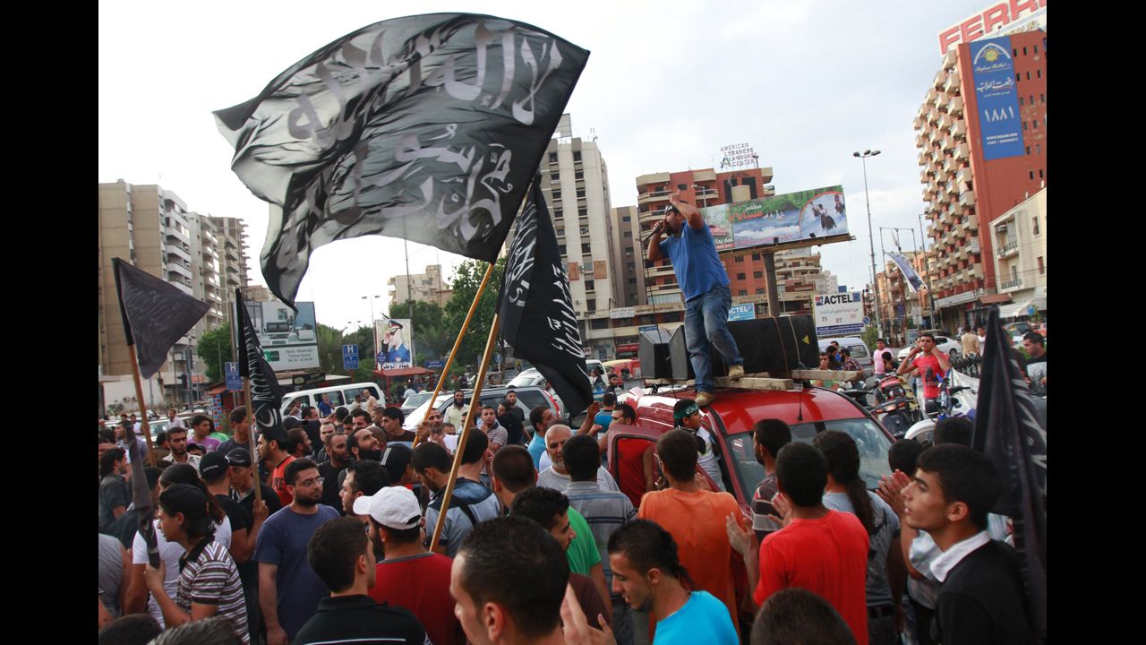 Protesters carry flags that read "There is no God but Allah, Mohammed is Allah's messenger" and chant during a protest in Tripoli, Lebanon, on Thursday.