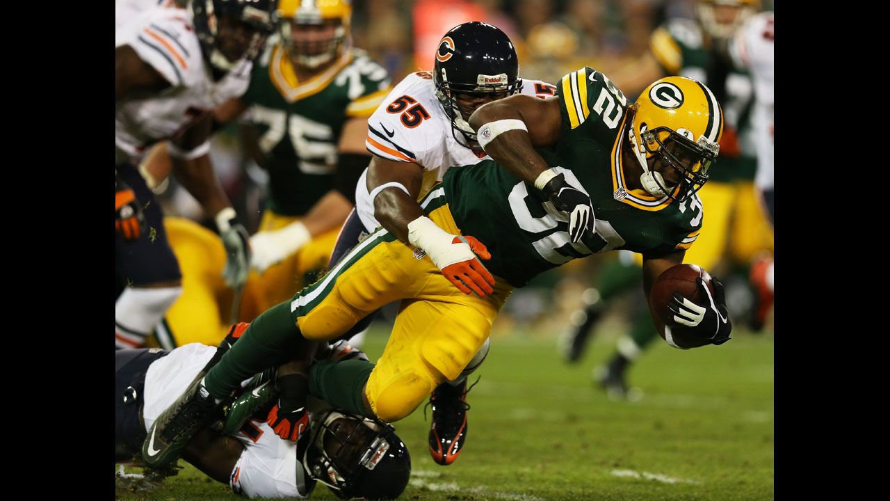 Running back Cedric Benson of the Green Bay Packers is tackled by No. 55 outside linebacker Lance Briggs and No. 21 strong safety Major Wright of the Chicago Bears on Thursday.