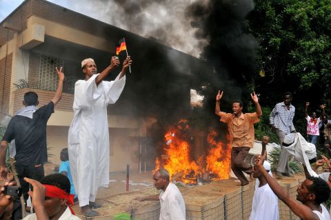 A Sudanese demonstrator burns a German flag after torching the German Embassy in Khartoum on Friday.