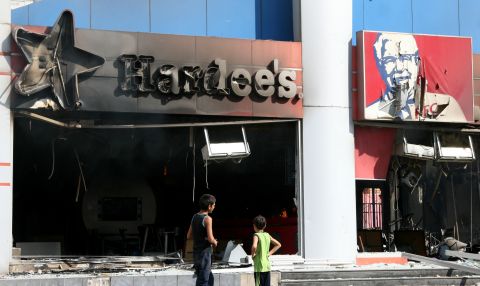 Boys inspect fast food chains Hardee's and KFC after they were torched during a protest in the northern Lebanese city of Tripoli on Friday.