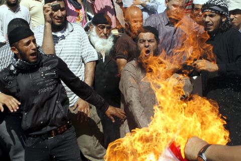 Jordanian protesters burn a U.S. flag near the U.S. Embassy in Amman on Friday.
