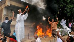 A Sudanese demonstrator burns a German flag after torching the German embassy in Khartoum on September 14, 2012