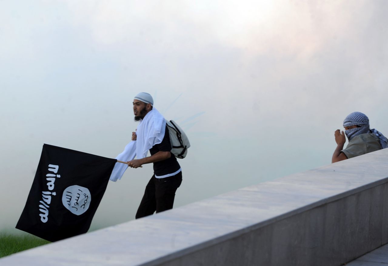 A Tunisian protester holds an Al-Qaeda affiliated flag amid the smoke coming from the tear gas fired by riot police outside the U.S. Embassy in Tunis on Friday.