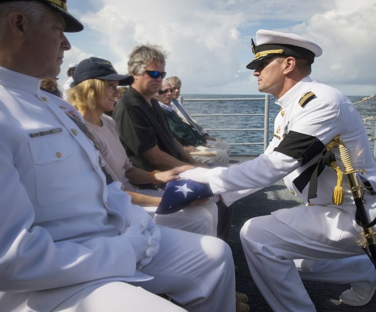 U.S. Navy Capt. Steve Shinego, commanding officer of the USS Philippine Sea, presents the U.S. flag to Carol Armstrong following the burial at sea service.