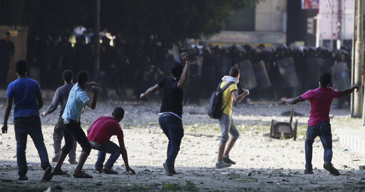 Protesters throw stones toward riot police during clashes along a road leading to the U.S. Embassy near Tahrir Square in Cairo on Friday, September 14.