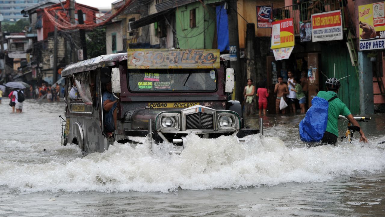 A jeepney pushes through a flooded street in Manila on Saturday.