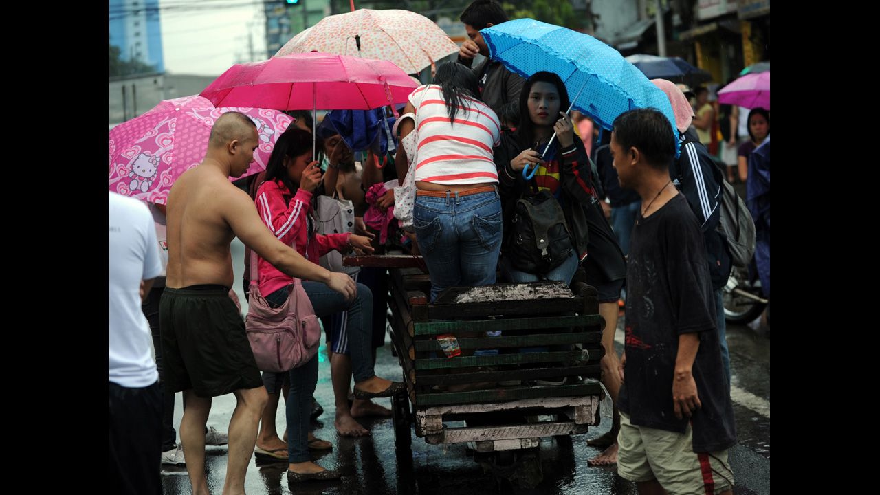 Stranded passengers are transported on a wooden pushcart in Manila.