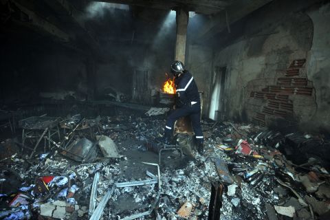 A Tunisian firefighter works inside a destroyed school building in the grounds of the American school in Tunis, Tunisia, on Saturday. Four people were killed and almost 50 injured in an attack on the U.S. Embassy in Tunis the day before by protesters angry over an anti-Islam film, the health ministry said. 