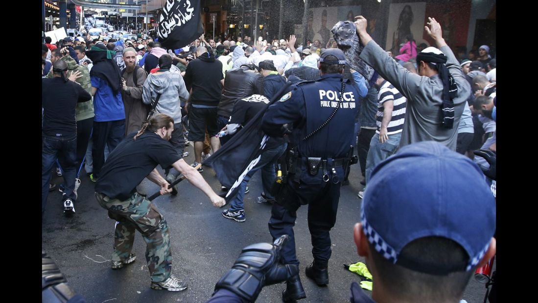 A protester hits a policeman with a pole in Sydney's central business district on Saturday, September 15. Anger over an anti-Islam video, "The Innocence of Muslims," spread to Australia on Saturday, and protesters took to the streets of the country's capital.