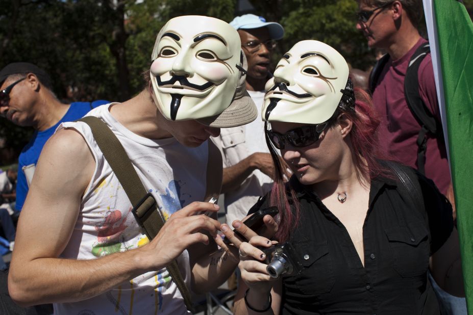 Occupy Wall Street protesters check their cell phones in Washington Square Park on Saturday.