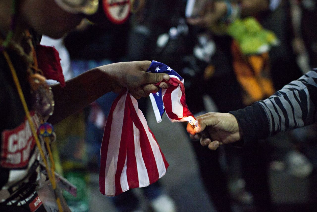 An Occupy Wall Street protester, who said she was not acting as part of the overall Occupy movement but as an individual, lights an American flag on fire during the march in New York City on Saturday.