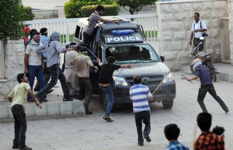 Protesters attack a police van outside the U.S. Consulate in Karachi on Sunday.