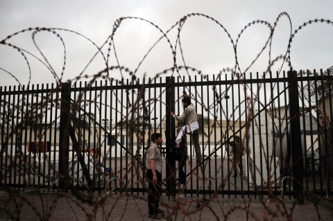 A protester climbs on a gate of the U.S. Consulate in Karachi, Pakistan, on Sunday.