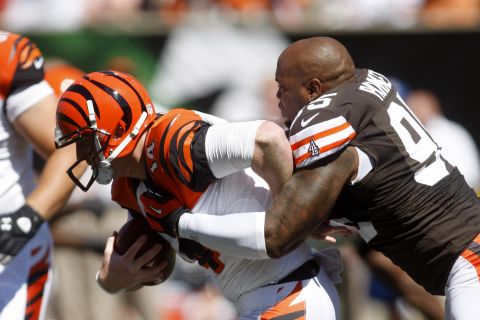 Quarterback Andy Dalton of the Cincinnati Bengals is tackled by Juqua Parker of the Cleveland Browns on Sunday at Paul Brown Stadium in Cincinnati.