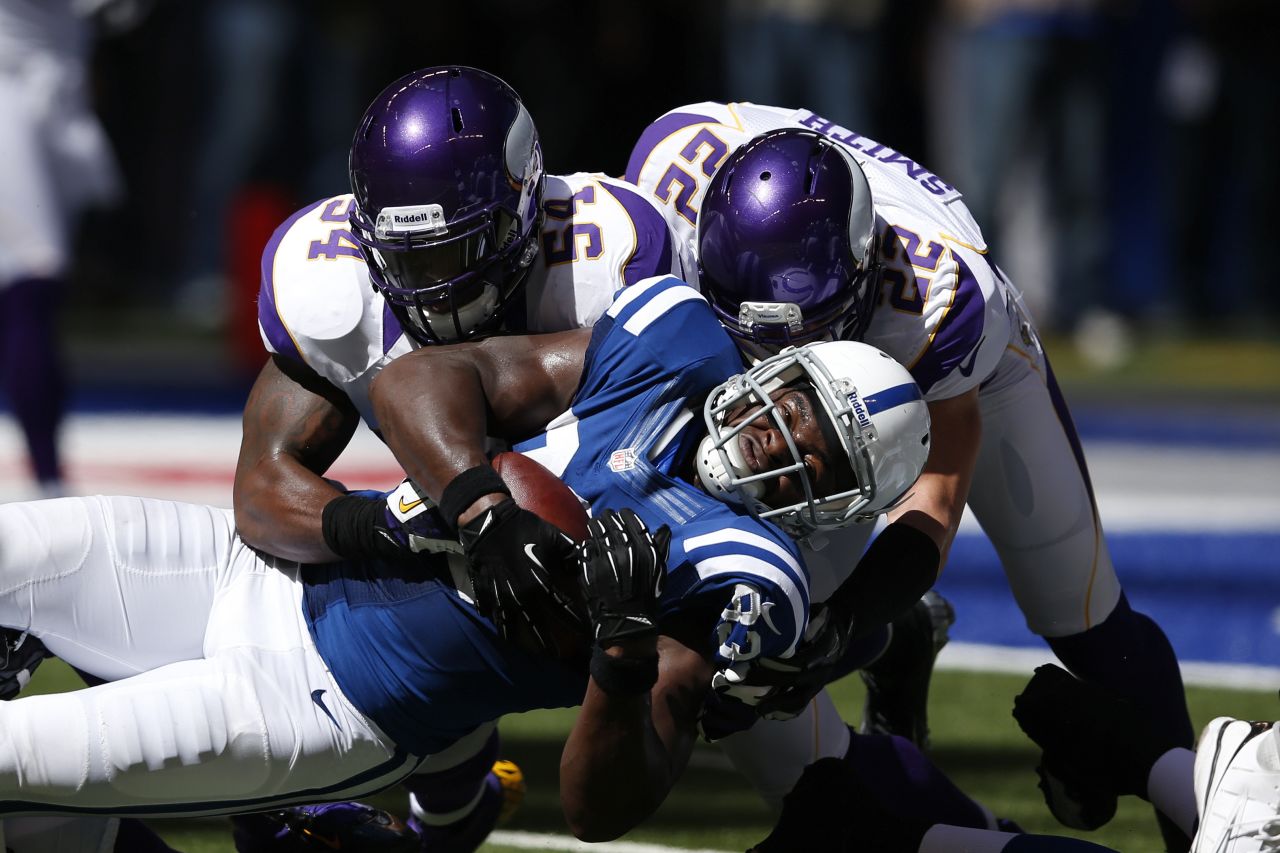 Jasper Brinkley, left, and Harrison Smith of the Minnesota Vikings tackle tight end Dwayne Allen of the Indianapolis Colts during the first half of Sunday's game.