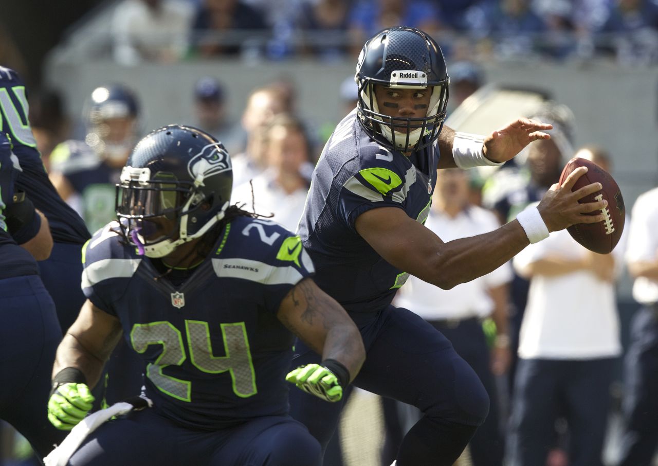 Russell Wilson of the Seattle Seahawks, right, rolls out of the pocket while Marshawn Lynch blocks during Sunday's game against the Dallas Cowboys at CenturyLink Field in Seattle.
