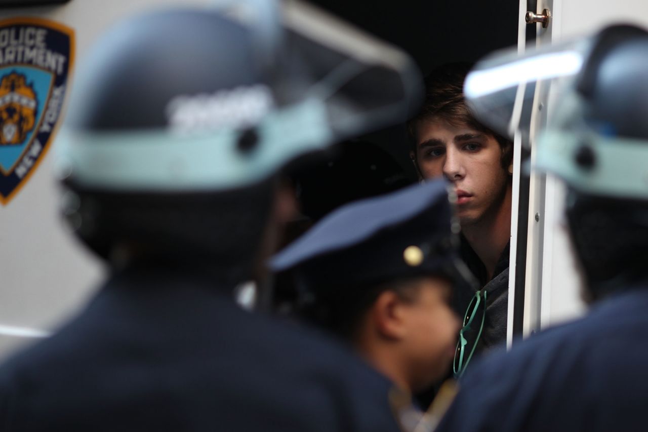 A protester looks out from a police van after being arrested on Monday.