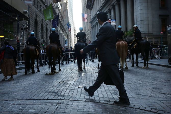 A man walks by a police blockade along Wall Street during Occupy Wall Street demonstrations on Monday.