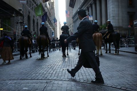 A man walks by a police blockade along Wall Street during Occupy Wall Street demonstrations on Monday.