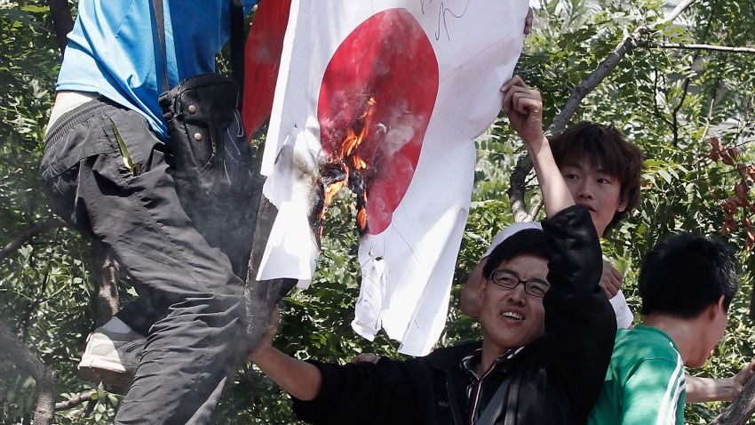 Chinese demonstrators burn a Japanese flag during a protest over the disputed islands in the east China Sea on September 15, 2012 in Beijing.