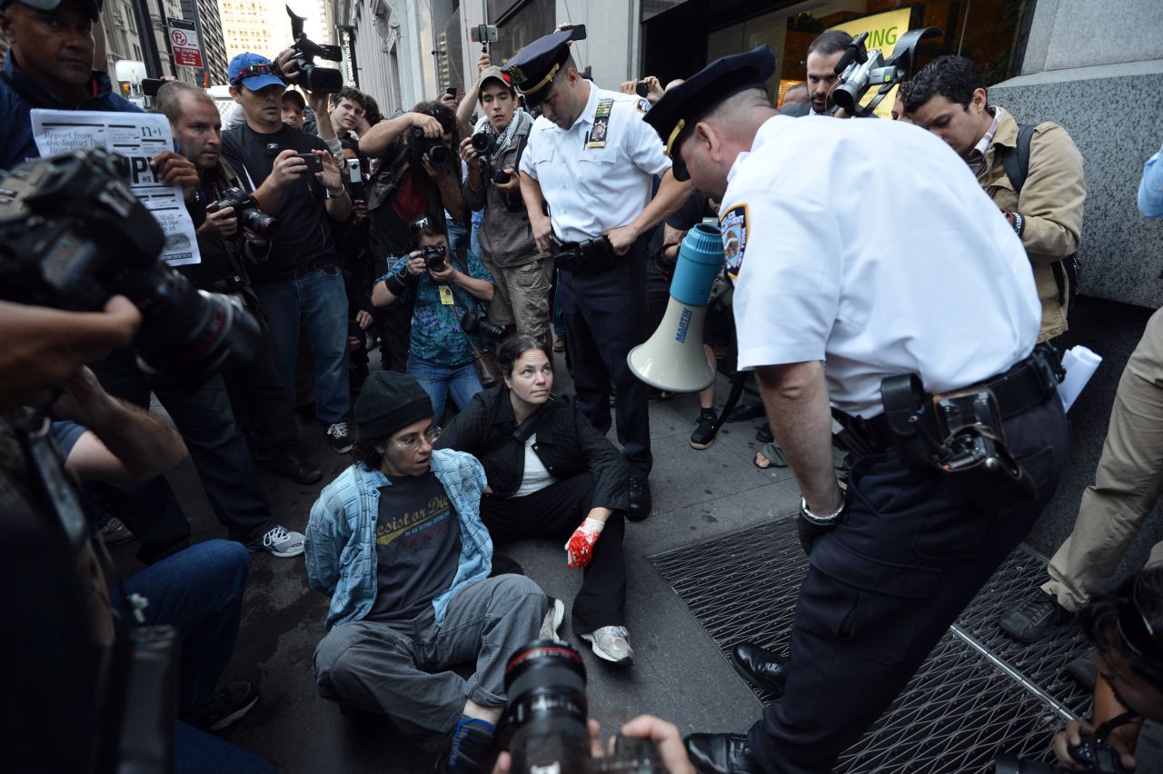 An officer warns people they will be arrested for blocking a sidewalk during the Occupy Wall Street protest on Monday in New York.