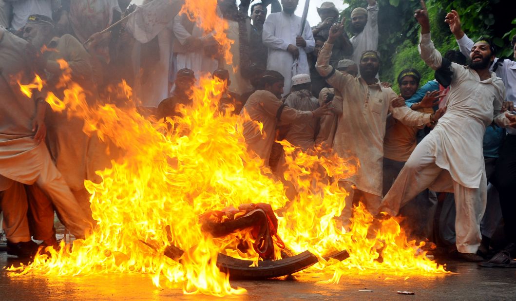 Sunni Muslims burn a U.S. flag during a protest in Lahore, Pakistan, on Monday. Protests entered their second week, with demonstrators taking to the streets in Pakistan, Afghanistan, Indonesia and Lebanon.