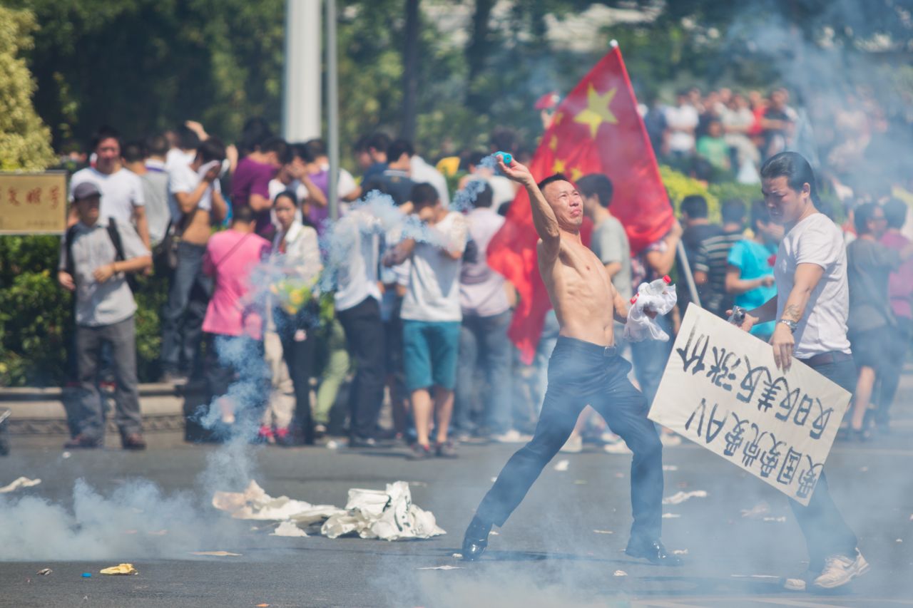  A protester hurls a gas cannister during a demonstration over the disputed Diaoyu Islands, which is also known as Senkaku by Japan, in Shenzhen, China.